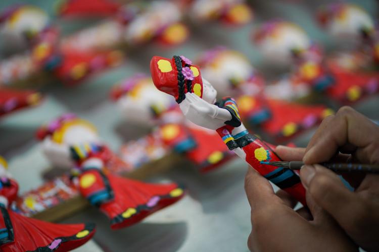 云南省文山壮族苗族自治州西畴县瓦厂村村民在制作彩绘文创产品(3月27